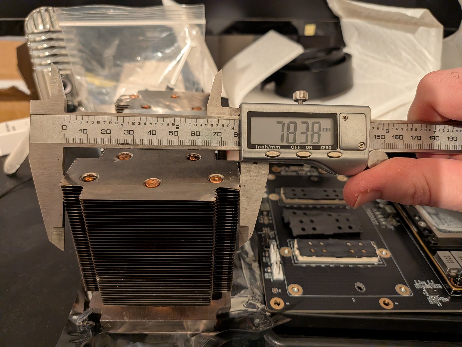 Measuring the heatsink with digital calipers, reading 78.38mm